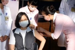 A nurse administers a dose of Medigen Vaccine Biologics Corp's COVID-19 vaccine, a domestically developed vaccine, for Taiwan President Tsai Ing-wen at National Taiwan University Hospital in Taipei, Taiwan, August 23, 2021.