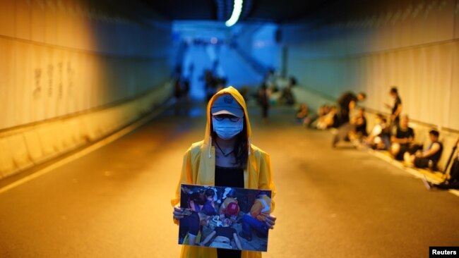 一位抗议者举着一名被打伤的抗议者的图片，要求香港特首林郑月娥辞职以及香港政府撤回《逃犯条例》修订方案。(2019年6月17日)