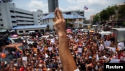 FILE - Thanathorn Juangroongruangkit, leader of the Future Forward Party flashes a three finger salute to his supporters as he leaves a police station after hearing a sedition complaint filed by the army in Bangkok, Thailand, Apr. 6, 2019. 