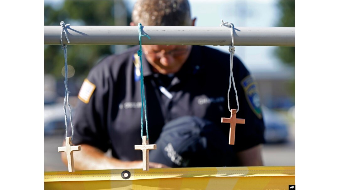 A police chaplain pays his respects July 18, 2016, at a makeshift memorial at the fatal shooting scene in Baton Rouge, Louisiana, where three law enforcement officers were ambushed and killed by a lone gunman on Sunday.