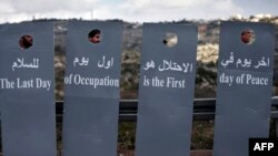 Militants de la paix israéliens et palestiniens lors d'une marche de la paix près d'un barrage entre la ville cisjordanienne de Beit Jala et Jérusalem le 15 janvier 2016. (AFP/Thomas Coex)