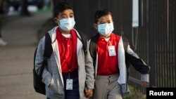 Students wearing protective face masks head back to school on the first day of school amid the COVID-19 pandemic in Houston, Texas, August 23, 2021.