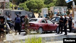 Israeli security forces gather at the scene where a female Palestinian was shot dead by Israeli troops at the entrance to Kiryat Arba near the West Bank city of Hebron, June 24, 2016.