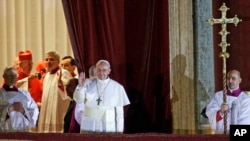 Pope Francis waves to the crowd from the central balcony of St. Peter's Basilica at the Vatican, March 13, 2013. 