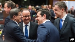 Turkish Prime Minister Ahmet Davutoglu, left, speaks with, from left, French President Francois Hollande, Greek Prime Minister Alexis Tsipras and Estonian Prime Minister Taavi Roivas during a meeting at an EU summit in Brussels, March 18, 2016. 