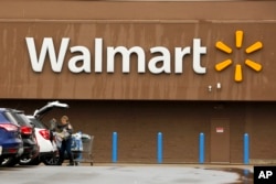 FILE - A shopper loads her car after shopping at a Walmart in Pittsburgh, Feb. 22, 2018.