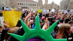 En Boston, un manifestante lleva un sombrero de la Estatua de la Libertad y aplaude durante una manifestación celebrada en protesta contra la orden del presidente Donald Trump que restringe el viajes a los Estados Unidos.