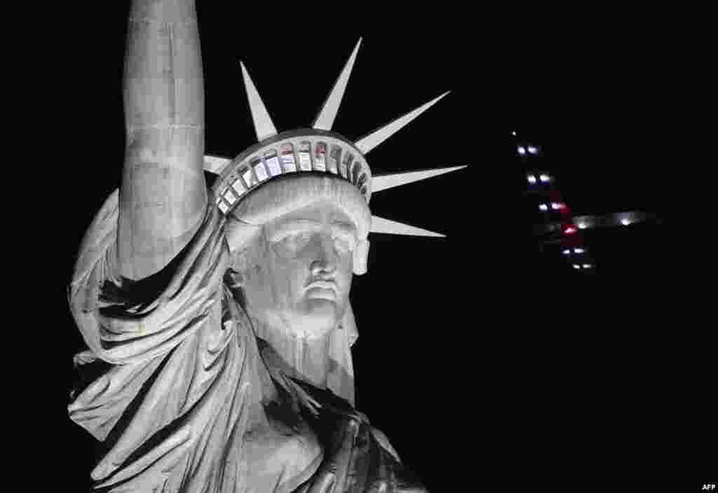 The Solar Impulse 2 aircraft flies over the Statue of Liberty before landing at JFK airport in New York, June 11, 2016.