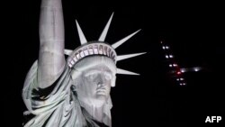 The Solar Impulse 2 aircraft flies over the Statue of Liberty before landing at JFK airport June 11, 2016 in New York. Solar Impulse 2 landed in New York early June 11, after flying by the Statue of Liberty at the end of the US portion of its bid to circl