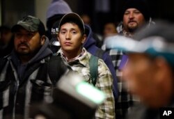 In this March 6, 2018 photo, farmworkers and others cross in the pre-dawn hours from Mexicali, Mexico, through the Calexico Port of Entry in Calexico, Calif.