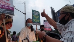 Perwakilan Orang Muda Katolik, Pandu (baju putih berkalung salib) membagikan takjil pada warga muslim di Solo Baru, Jalur perbatasan kota Solo dan Kabupaten Sukoharjo, Jumat (7/5). (Foto : VOA/ Yudha Satriawan)