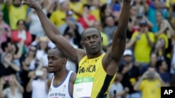 Usain Bolt de la Jamaïque court à côté de James Dasaolu de la Grande-Bretagne lors de 100 mètres-messieurs aux Jeux Olympiques d'été de 2016 au stade olympique à Rio de Janeiro, au Brésil, 13 août 2016. 