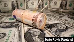 Novčanice od jednog dolara i na njima rolna sa nekoliko novčanica od 50 eura (Foto: Reuters/Dado Ruvić)