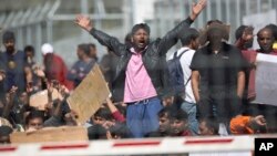 Refugees and migrants most of them from Pakistan protest against EU-Turkey deal about migration inside the entrance of Moria camp in the Greek island of Lesbos on April 5, 2016. 