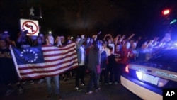 Une voiture de police circulant à Watertown alors que les habitants sont dans la rue pour célébrer l'arrestation de Dzhokhar Tsarnaev, suspect des attentats de Boston – photo prise le 19 avril 2013