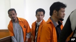 FILE - Suspected militants Abdul Hakim (from left), Ahmad Junaedi and Tuah Febriwansyah attend trial at West Jakarta District Court in Jakarta, Indonesia, Oct. 12, 2015.