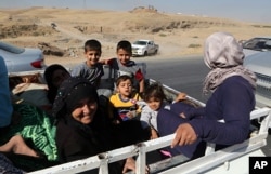 People return back to Kirkuk, 290 kilometers (180 miles) north of Baghdad, Oct. 17, 2017. Thousands of civilians are streaming back to Kirkuk, a day after fleeing as Iraqi troops pushed Kurdish forces out of the disputed oil-rich city.