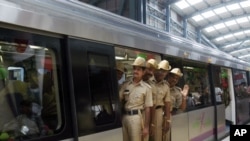 Indian policemen take a ride during the inaugural run of the Bangalore Metro rail in Bangalore, India, October 20, 2011.