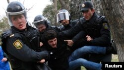 FILE - Police officers detain a man during a rally in Baku, Azerbaijan, Jan. 26, 2013. Azerbaijan has decided to give amnesty to over 400 people, including a number of political activists and journalists.