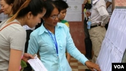 Cambodian Election workers check the voter rolls at a polling station in Kampong Cham, northeast of Phnom Penh, July 28, 2013. (Heng Reaksmey/VOA Khmer)
