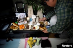 Lee Jae-hwan meletakkan makanan hewan di meja untuk anjing peliharaannya, Kkotgae, yang sudah mati, di rumahnya di Namyangju, Korea Selatan, 10 Januari 2019. (Foto: Reuters)