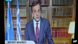 In this image taken from NET state television channel Greece's Prime Minister Antonis Samaras makes an announcement to the Greek people from his office in Athens, April 15, 2013.