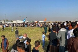 Warga Afghanistan berkerumun di bandara, menunggu pesawat lepas landas dari Kabul, 16 Agustus 2021. (Foto: Shakib Rahmani / AFP)