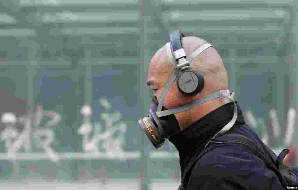 A man wearing a mask is seen on a street in Beijing, May 2, 2013. Street-level anger over air pollution that blanketed many northern cities this winter spilled over into online appeals for Beijing to clean water supplies.