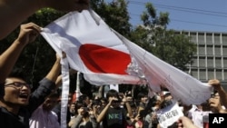 Demonstran Tiongkok membakar bendera Jepang dalam aksi protes anti Jepang di depan Kedutaan Jepang di Beijing (15/9).