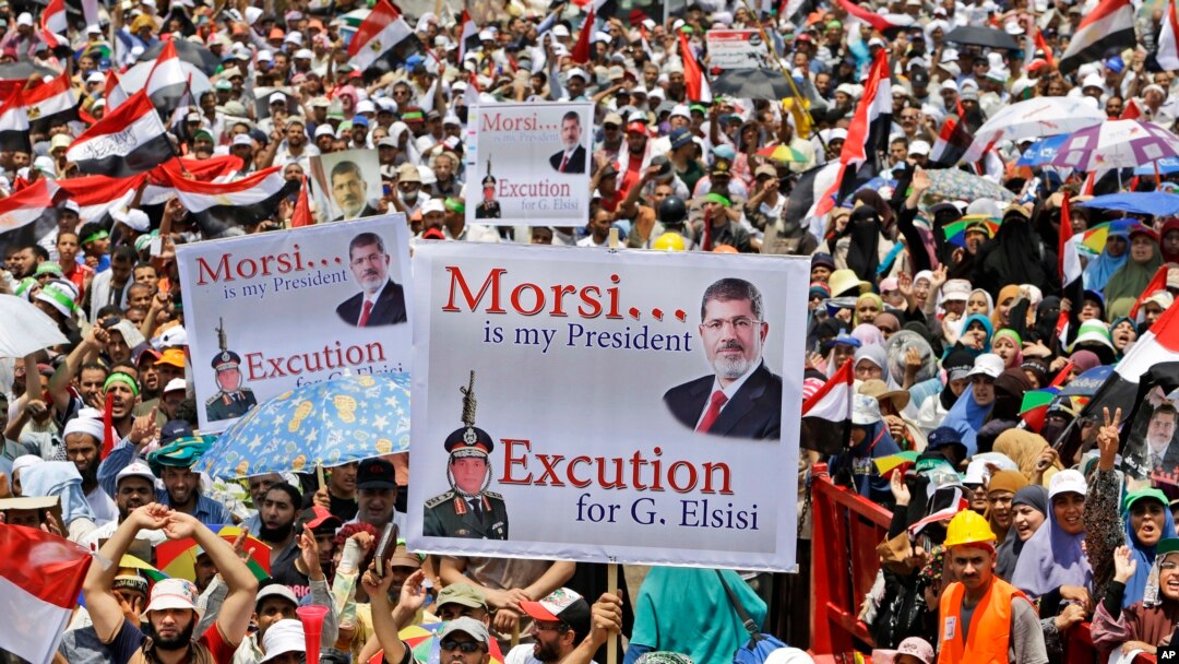 Supporters of Egypt's ousted President Mohammed Morsi hold up placards as they shout slogans during a demonstration where protesters have installed their camp, at Nasr City, Cairo, Egypt, July 19, 2013.