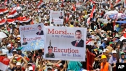 Supporters of Egypt's ousted President Mohammed Morsi hold up placards as they shout slogans during a demonstration where protesters have installed their camp, at Nasr City, Cairo, Egypt, July 19, 2013.