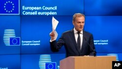 Presiden Dewan Eropa Donald Tusk memegang dokumen dari Inggris dalam pertemuan dengan media di Brussels, 29 Maret 2017. (AP Photo/Virginia Mayo) 