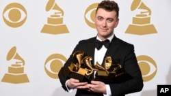 Sam Smith poses in the press room with the awards for best new artist, best pop vocal album for “In the Lonely Hour”, song of the year for “Stay With Me”, and record of the year for “Stay With Me” at the 57th annual Grammy Awards at the Staples Center on 