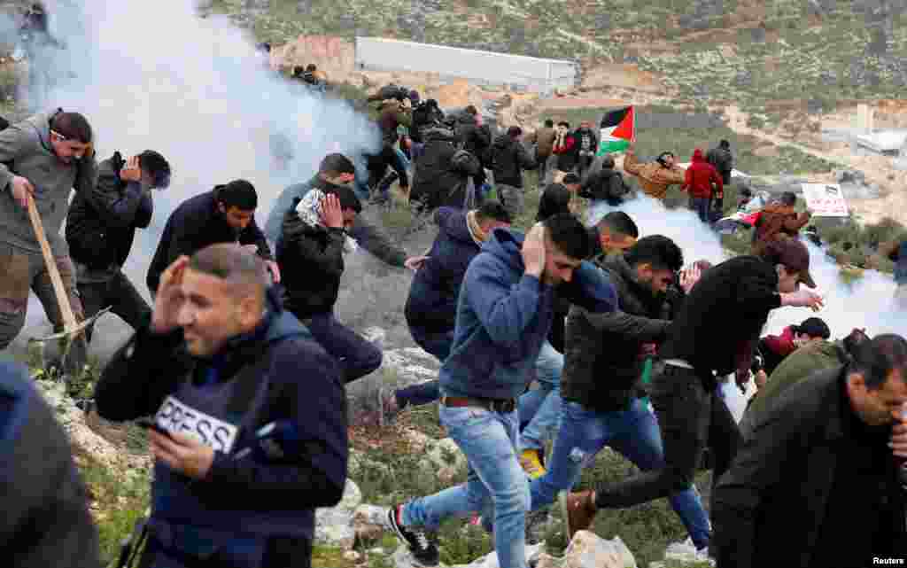 Para demonstran Palestina berlari untuk menghindari gas air mata yang ditembakkan polisi Israel pada aksi unjuk rasa memrotes pembangunan permukiman Yahudi di Beita, dekat Nablus, kawasan pendudukan Israel di Tepi Barat, Palestina.