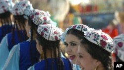 Women wearing traditional Uzbek costumes look on during a celebration to mark Nowruz.