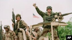 Un soldat de la Marine américaine lève son doigt à bord d’une camionnette à la réouverture de l’ambassade des Etats-Unis à Mogadiscio, Somalie, 10 décembre 1992