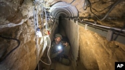 An Israeli army officer shows journalists a tunnel allegedly used by Palestinian militants for cross-border attacks from Gaza into Israel, July 25, 2014.