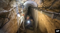 An Israeli army officer shows journalists a tunnel allegedly used by Palestinian militants for cross-border attacks from Gaza into Israel, July 25, 2014.