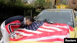 Un conducteur de taxi albanais embrasse le drapeau américain après la victoire de Trump, à Tirana, Albanie, le 10 novembre 2016.