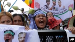 Supporters shout slogans on a blocked main street near the Phnom Penh Municipality Court during their gathering to call for the release of anti-governments protesters who were arrested in a police crackdown, in Phnom Penh, file photo. 