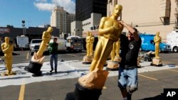 Los artistas escénicos mueven las estatuas de Oscar fuera del sol el miércoles, 22 de febrero de 2017, en Los Ángeles. Los premios número 89 de la Academia se llevarán a cabo el domingo.