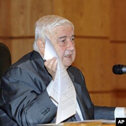 Syria's Foreign Minister Walid al-Moualem shows documents during a news conference in Damascus, November 14, 2011, in this handout photograph released by Syria's national news agency SANA.