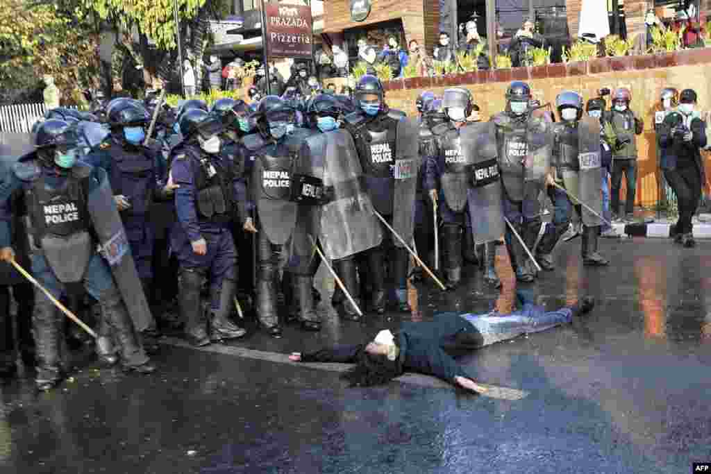 A protester from the civil society lies down in front of policemen during a demonstration against the dissolution of the country&#39;s parliament in Kathmandu, Nepal.