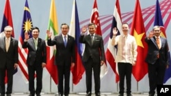 Bộ trưởng Ngoại giao Việt Nam Phạm Bình Minh và ông Vương đứng gần nhau trong khi chụp ảnh chung với các nhà ngoại giao ASEAN ở Singapore.