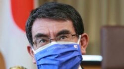 In this March 29, 2021, file photo, Japanese Vaccine Minister Taro Kono wearing a face mask with Japanese and EU flags on it speaks during an interview in Tokyo. (AP Photo/Koji Sasahara, File)