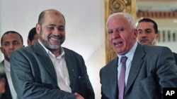 Palestinian Fatah delegation chief Azzam al-Ahmed (R) shakes hands with Hamas deputy leader Mussa Abu Marzuq after a joint press conference in Cairo on April 27, 2011 as rival Palestinian groups agreed to set up a transitional unity government and hold el