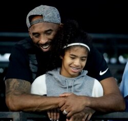 In this July 26, 2018 file photo former Los Angeles Laker Kobe Bryant and his daughter Gianna watch during the U.S. national championships swimming meet in Irvine, Calif. (AP Photo/Chris Carlson)