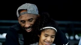 In this July 26, 2018 file photo former Los Angeles Laker Kobe Bryant and his daughter Gianna watch during the U.S. national championships swimming meet in Irvine, Calif. (AP Photo/Chris Carlson)