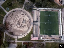 FILE - The pre-Columbian archeological site La Luz is flanked by a private soccer field players rent in Lima, Peru, Sept. 22, 2017.