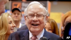 Berkshire Hathaway Chairman and CEO Warren Buffett laughs while touring the exhibit floor at the CenturyLink Center in Omaha, Neb., May 6, 2017, where company subsidiaries display their products.